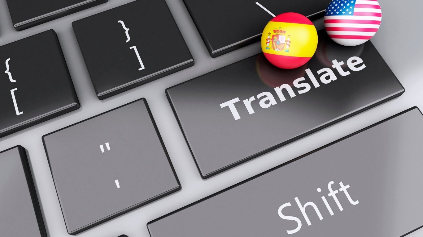 Teclado con tecla "Translate" y banderas de EE.UU. y España, representando traducción inglés-español.